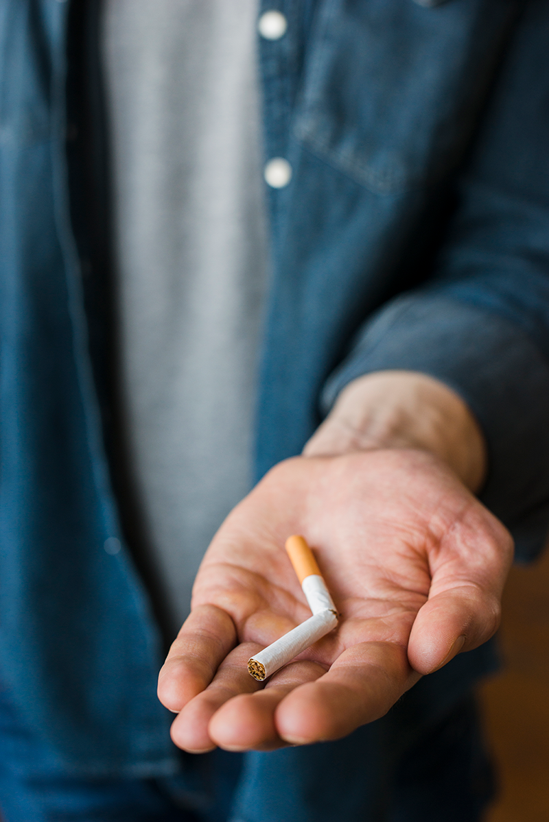 man-holding-broken-cigarette-his-hand